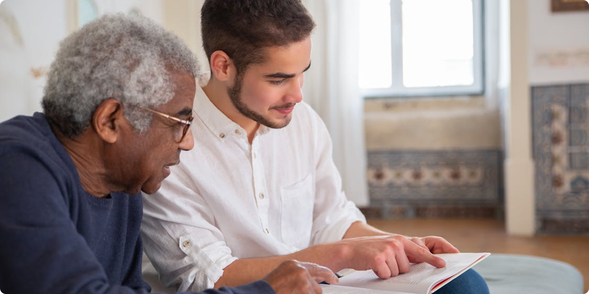 Caregiver and senior holding hands and smiling
