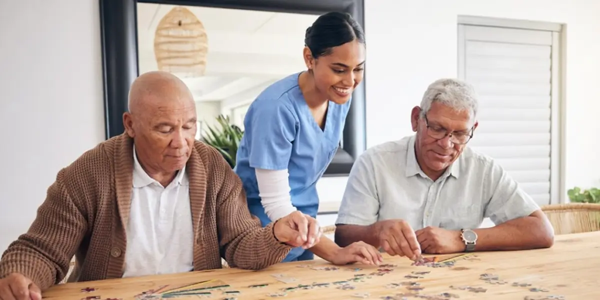 Caregiver and senior holding hands and smiling
